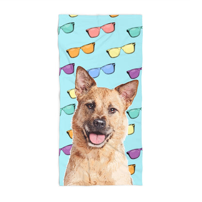 Towel with a dog's face and colorful sunglasses on a blue background