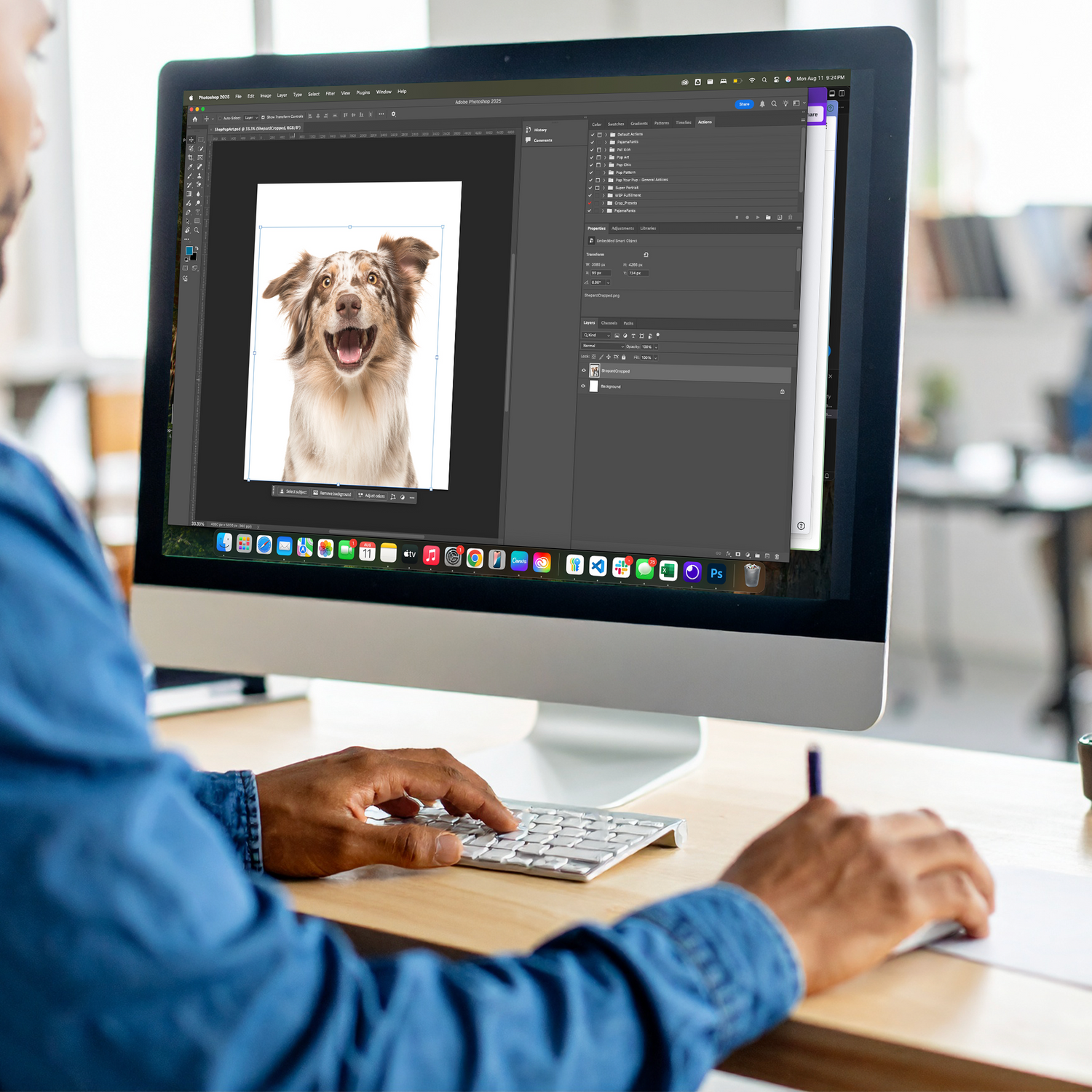 Person using a computer with a photo of a dog on the screen in an office setting